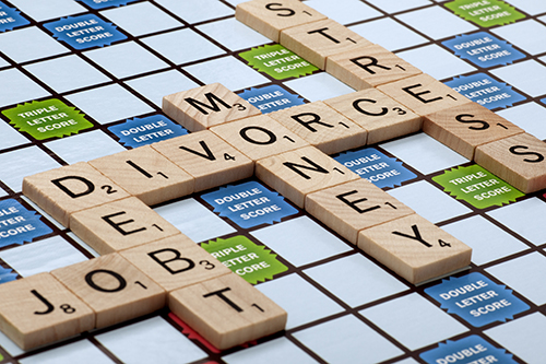 scrabble board with Divorce, Money, Debt spelled out